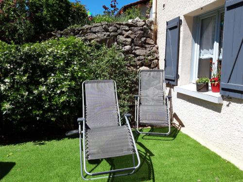 two lawn chairs sitting on the grass near a house at La Meïzou, gîte - chambres d hôtes à Champeix in Champeix