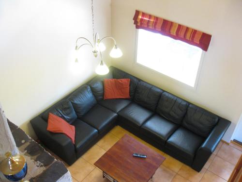a black leather couch in a living room with a window at Rattle Nest in Loimaa