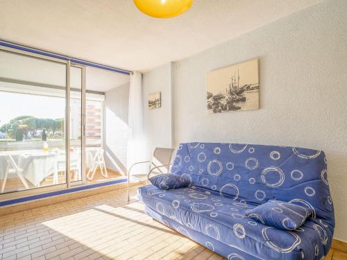 ein blaues Sofa im Wohnzimmer mit Balkon in der Unterkunft Studio Floralies I-4 by Interhome in Le Grau-du-Roi