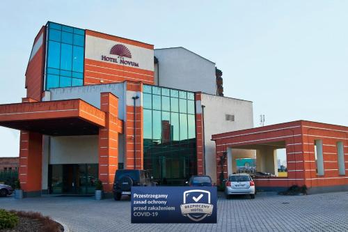 a building with a car parked in front of it at Hotel Novum & Spa in Niepołomice