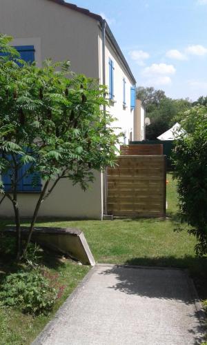 une maison avec une clôture et un arbre dans la cour dans l'établissement LES CHAMPS, à Cernoy-en-Berry