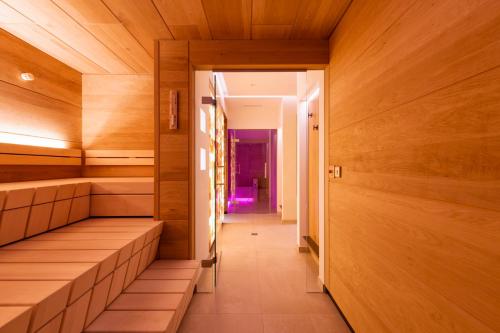 a sauna with wooden walls and a long corridor at Muntanella in Lech am Arlberg