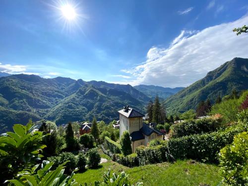 a small house on a hill with mountains in the background at Design Suite Cavagna in San Pellegrino Terme