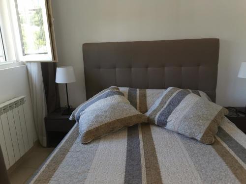 un lit avec deux oreillers dessus dans une chambre dans l'établissement Ou Souleou, à Bormes-les-Mimosas
