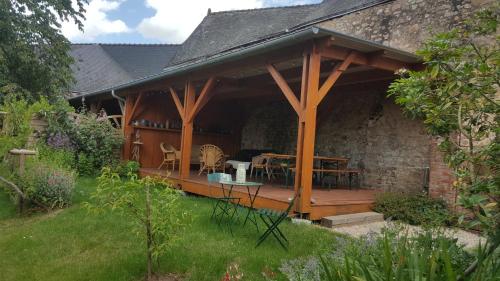 a wooden pavilion with a table in a garden at Les Hirondelles in Sainte-Suzanne