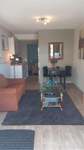 uma sala de estar com um sofá e uma mesa em 2 persoons appartement Le Garage em Frieschepalen