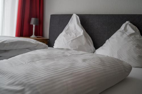a bed with white sheets and pillows on it at The Dubliner Hotel & Irish Pub in Heidelberg