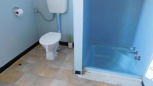 a bathroom with a toilet and a glass shower door at Cottage 53 - Topspot Cottages in Jurien Bay
