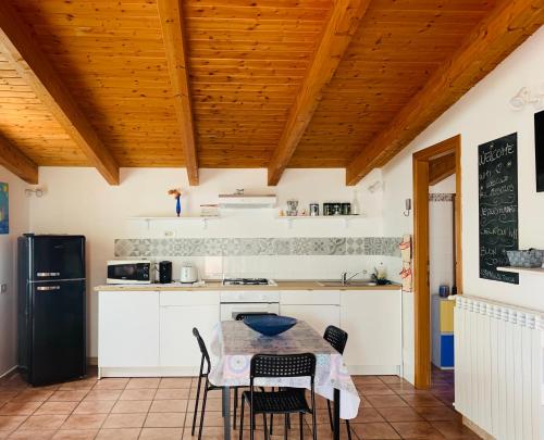 kuchnia z białymi szafkami oraz stołem i krzesłami w obiekcie Casa Mare al Circeo w mieście San Felice Circeo