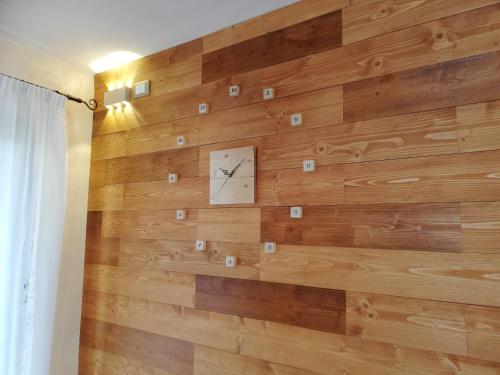 a wooden wall with a clock on it at Casetta next to the Creek Sebastiano Ricci in Belluno