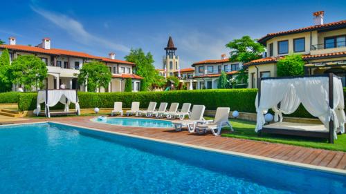 a swimming pool with lounge chairs and a hotel at Вила Бел Тауър - Villa Bell Tower in Balchik
