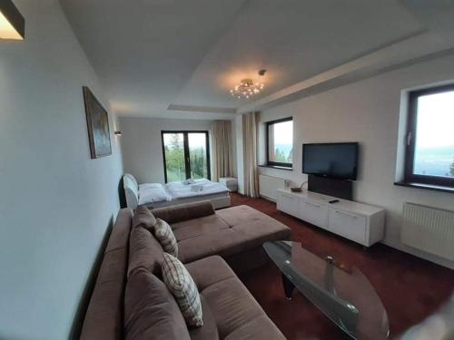 a living room with a couch and a flat screen tv at Apartmany Panorama 10X-90X in Štrbské Pleso