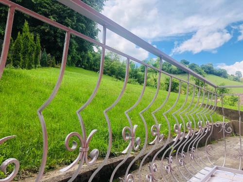 a metal fence with a field in the background at Hotel Poenita in Sighişoara