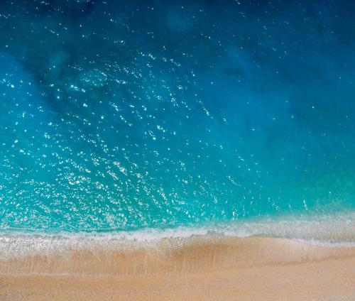 a beach with a droplets of water on the sand at Golden Beach Hotel in Chrissi Akti
