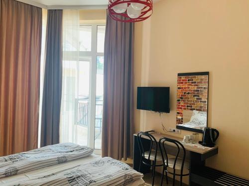 a hotel room with a bed and a desk and a window at Agora Studios in Plovdiv