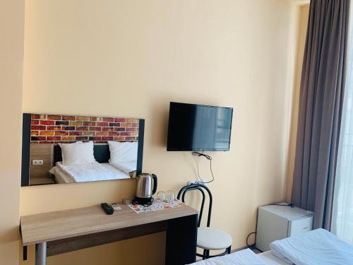 a hotel room with a bed and a tv on the wall at Agora Studios in Plovdiv