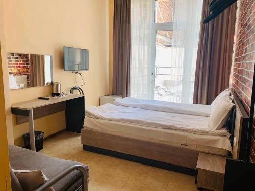 a bedroom with a bed and a desk and a window at Agora Studios in Plovdiv