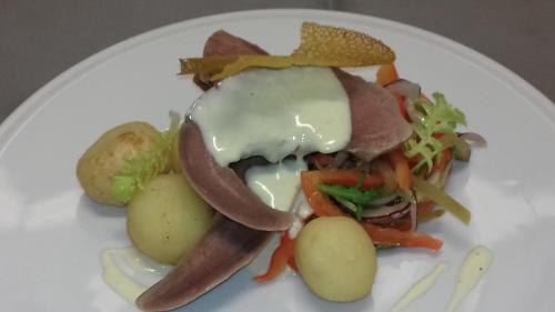 a white plate with a sandwich with potatoes and meat at Sosnowe Zacisze in Białystok