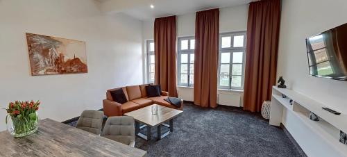 ein Wohnzimmer mit einem Sofa, einem Tisch und Stühlen in der Unterkunft Boardinghouse Emden in Emden
