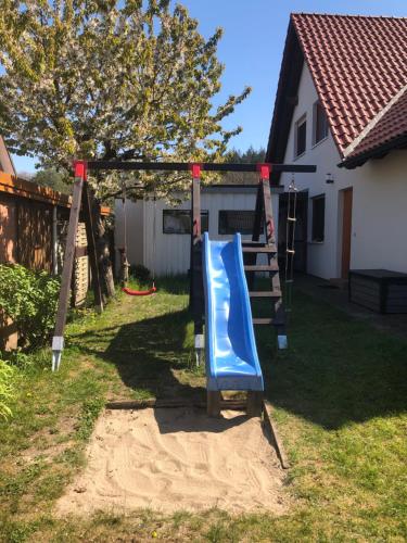 a playground with a blue slide in a yard at Ferienwohnung Störblick Schwerin in Raben Steinfeld