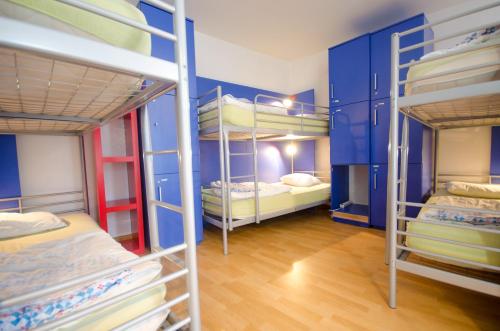 Habitación con 4 literas y paredes azules. en H2O Hostel, en Liubliana