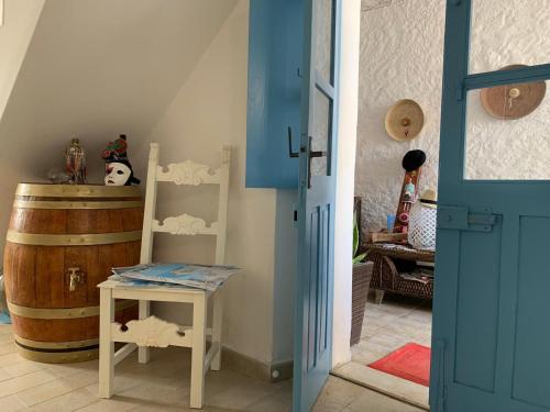 a room with a blue door and a table and a barrel at BnB Le Janas in Càbras