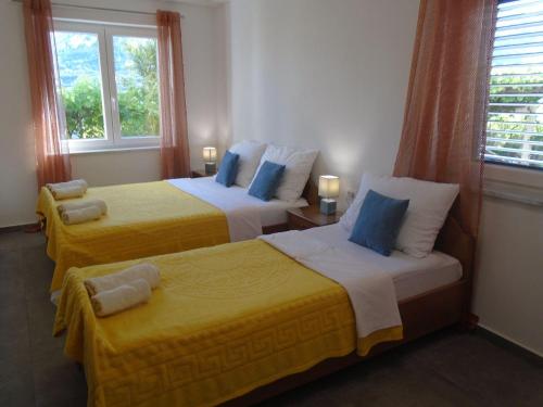 2 letti in una camera con giallo e blu di Apartment Antica a Baška