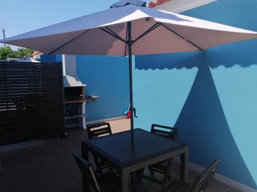 a table with an umbrella on a patio at Lisbon Beach Apartments 8 in Costa da Caparica