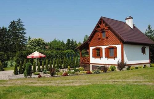 a small house in a yard with a garden at Domek w Bartoszymlesie in Stara Kiszewa
