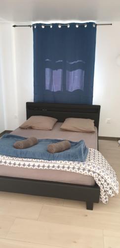 a bedroom with a bed with a blue headboard at La caz' à Chisy in Cilaos