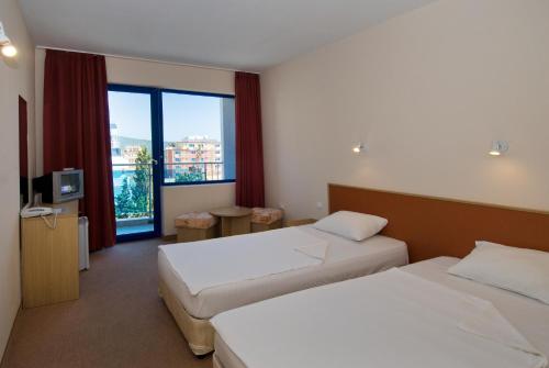 una camera d'albergo con due letti e una finestra di Hotel Nadia a Primorsko