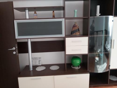 a entertainment center with a television and a shelf at Hotel Turist in Reşiţa