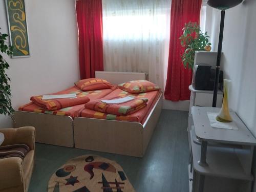 a small bedroom with a bed and a television at Hotel Turist in Reşiţa