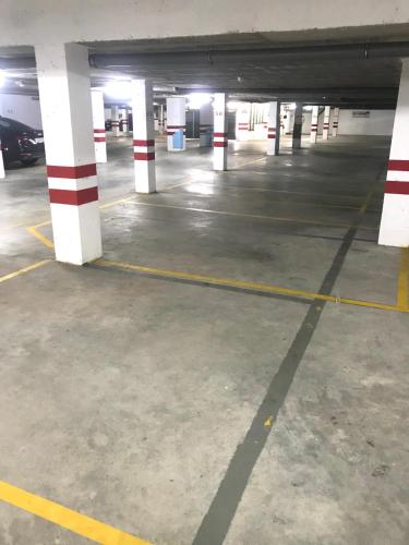 an empty parking garage with white and red columns at Fisterracons in Finisterre