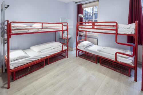 a room with three bunk beds and a window at Astor Museum Hostel in London