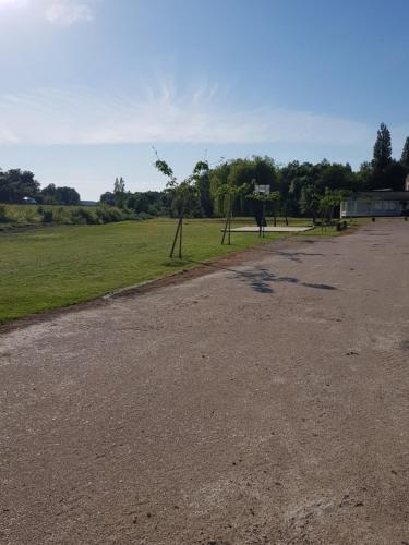 an empty parking lot with a basketball hoop in a field at Hôtel Restaurant Le Moulin de la Renne Adults Only proche Zoo de Beauval in Thésée