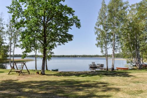 a park with a playground and a picnic table next to a lake at Duriu sodyba in Molėtai