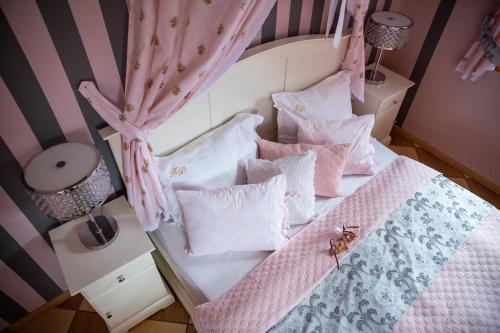 a bedroom with a bed with pink and white pillows at Karolowy Dwór in Wisła