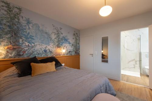 a bedroom with a bed with a large painting on the wall at O Thil in Aire-sur-lʼAdour