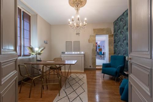 a dining room with a table and chairs and a chandelier at O Thil in Aire-sur-lʼAdour