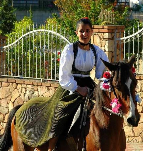 a woman in a dress riding a horse at Marina's apartment Ogliastra in Lotzorai