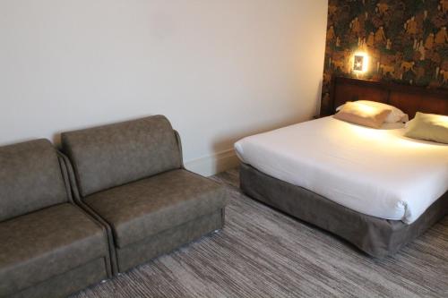a hotel room with a bed and a couch at Best Western de Diane in Nevers