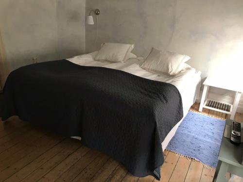 uma cama com um cobertor preto e almofadas em Brunius Bed and Breakfast em Lund