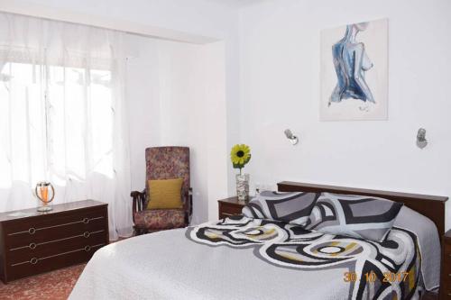 a bedroom with a bed and a chair at Apartamento en el centro de Alicante in Alicante