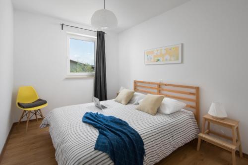 a bedroom with a bed with a blue blanket on it at Lemechi Casa Girasole Apartments in Rabac