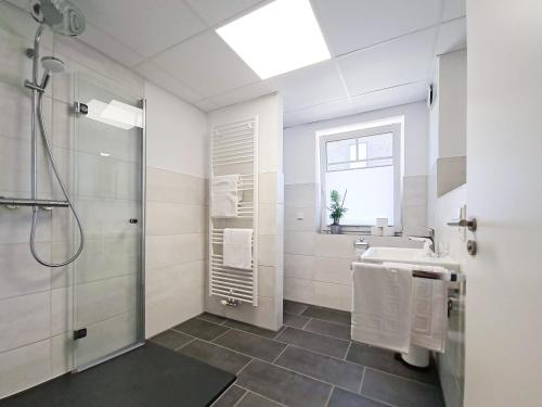 a white bathroom with a sink and a shower at StayCozy Bike&Ski Apartments, barrierefrei, free WIFI, Erdgeschoss in Winterberg