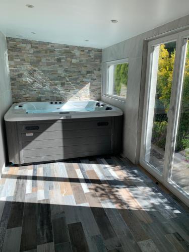 a bathroom with a tub and two windows at Relax & Spa - Séjour Romantique in Margny-lès-Compiègne
