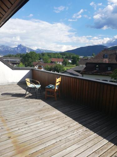 a patio with two chairs and a table on a deck at Hotel Wirt Z'Minsta in Altmünster