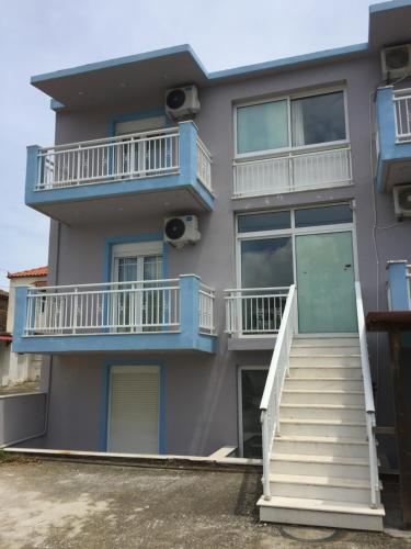 ein Apartmenthaus mit blauen und weißen Balkonen und Treppen in der Unterkunft My Lemnos Studios - Studio 1 in Repanídhion