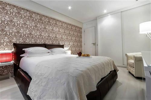 a bedroom with a large bed with a teddy bear sitting on it at InLoveApartments - City Center With Charm in Lisbon